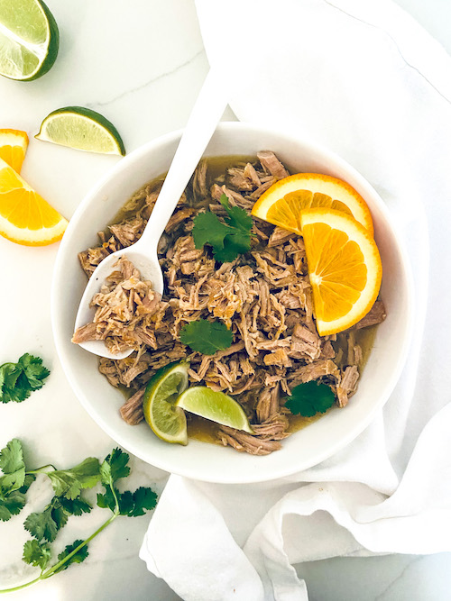 Shredded citrus mojo pork in a white bowl.