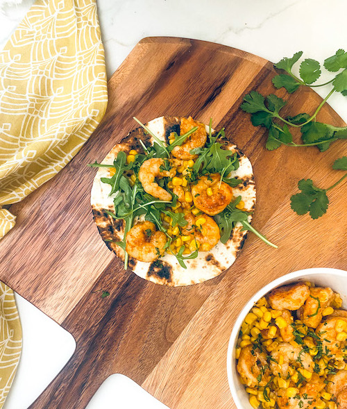 Blackened shrimp and cilantro on a tortilla.