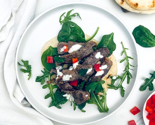 Greek style ribeye steak with spinach on a pita.