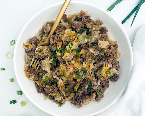 Ground beef egg roll in a bowl with a golden fork.