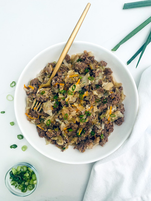 Ground beef egg roll in a bowl with a golden fork.
