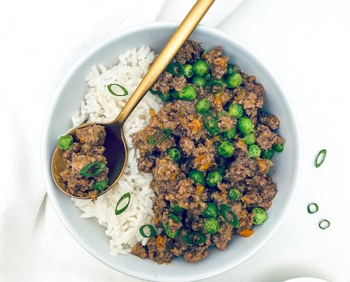 White bowl filled with rice and Korean ground beef with veggies.