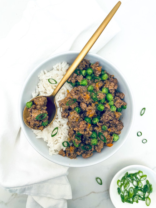 White bowl filled with rice and Korean ground beef with veggies.