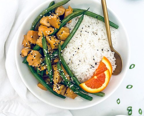 White rice next to honey orange chicken and green beans.