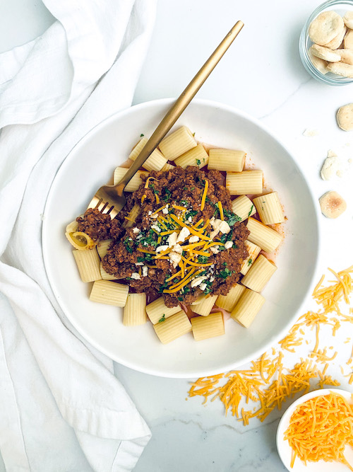 Cincinnati chili over rigatoni pasta in a white bowl.