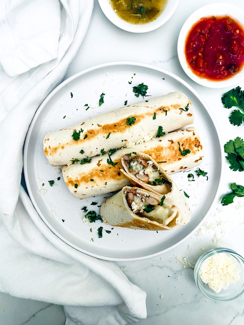 Black bean cheese taquitos on a white dinner plate.