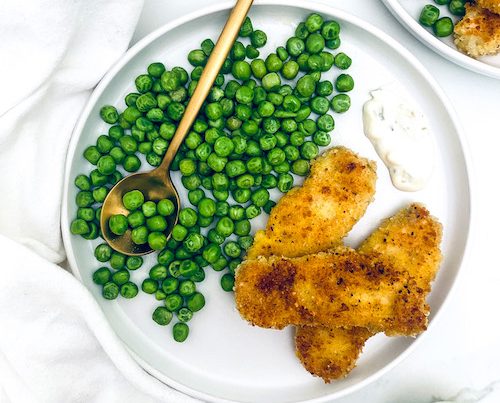 Lemon pepper fish sticks on a plate with peas.