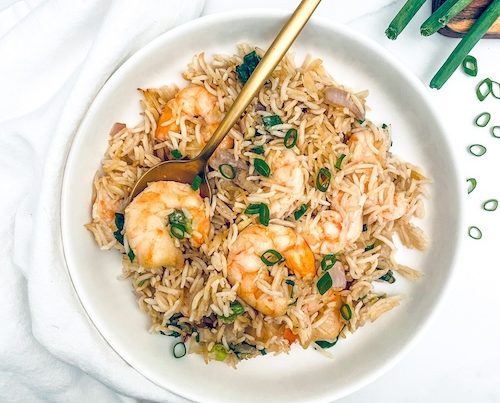 Thai seasoned shrimp over rice in a white bowl.