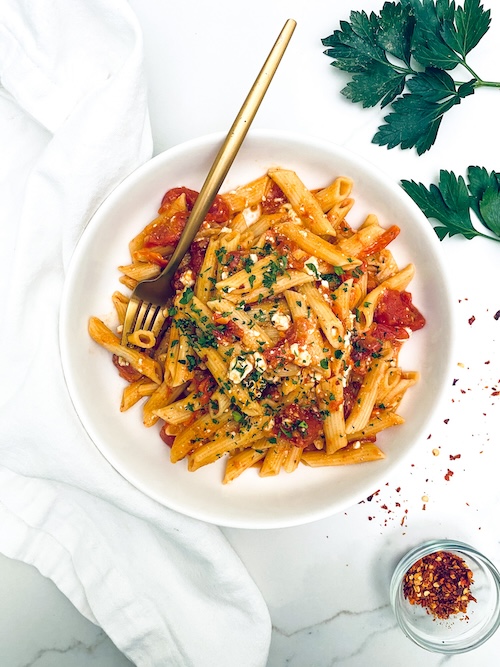 Viral TikTok feta pasta in a white bowl with a fork.