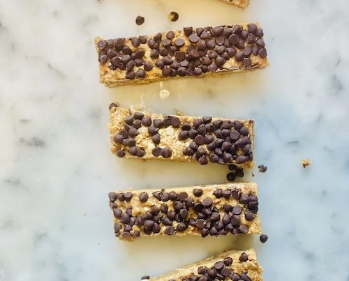 Chocolate peanut butter granola bars on a marble surface.