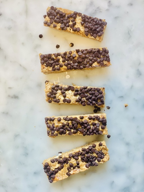 Chocolate peanut butter granola bars on a marble surface.