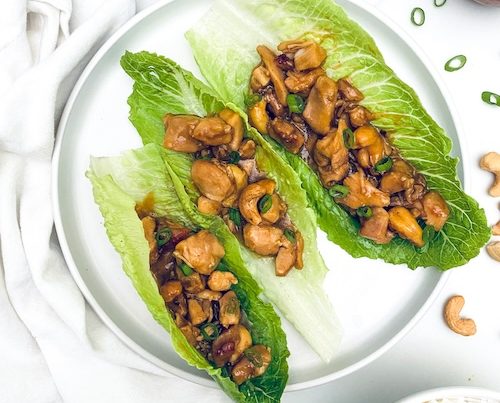 cashew chicken in lettuce wraps on a plate.