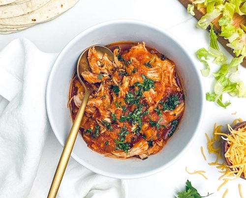 Ranchero chicken in a white bowl with a gold spoon.