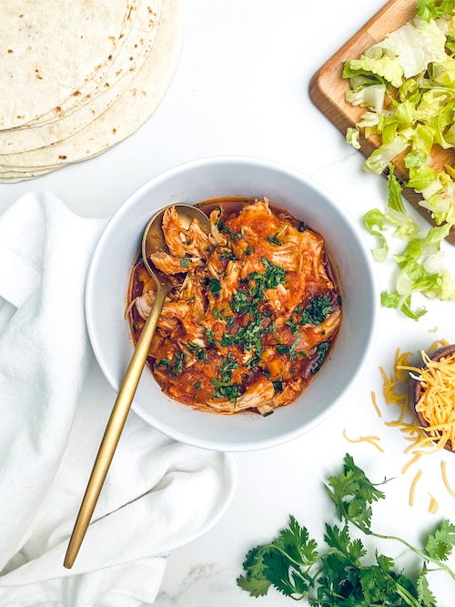 Ranchero chicken in a white bowl with a gold spoon.
