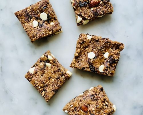 5 white chocolate oat bars on a white counter.