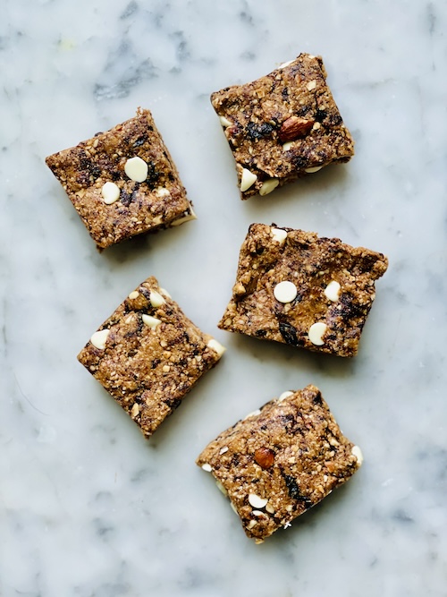 5 white chocolate oat bars on a white counter.