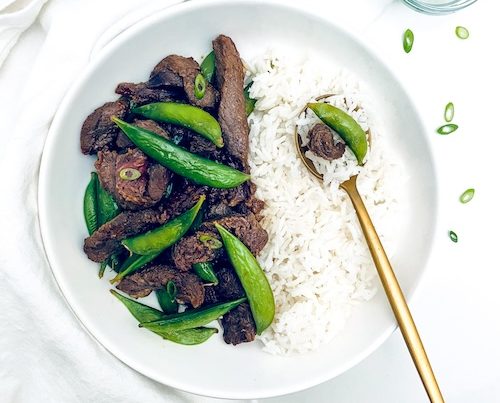 Japanese BBQ beef and rice on a white plate.