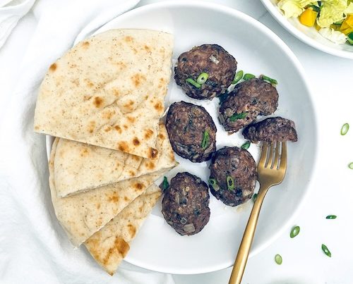Moroccan meatballs and pita on a white plate.