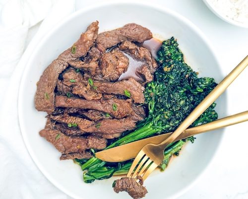 Beef bulgogi and broccolini on a plate.
