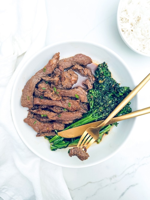 Beef bulgogi and broccolini on a plate.