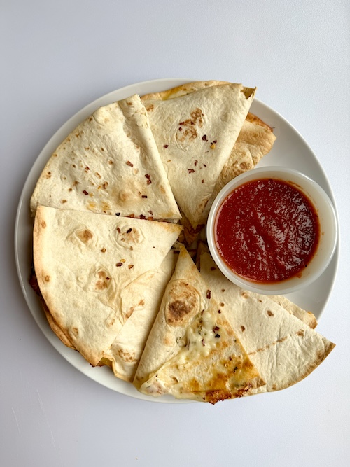 Pizza quesadilla on a plate.