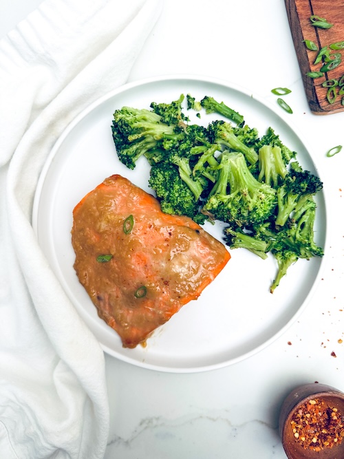 Honey glazed salmon and broccoli on a plate.