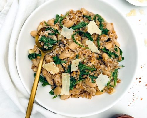 A bowl of farro with cannelloni beans and nuts.