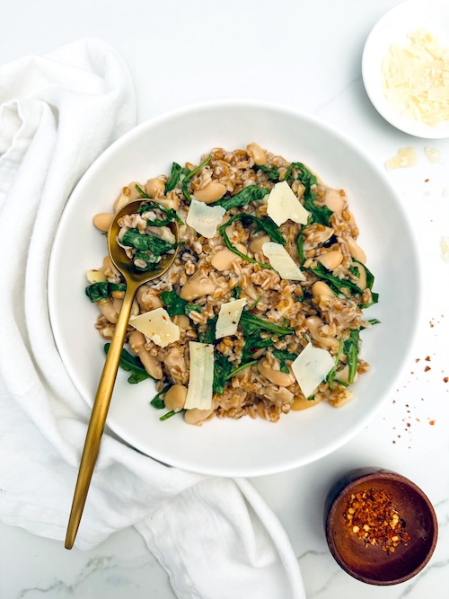 A bowl of farro with cannelloni beans and nuts.