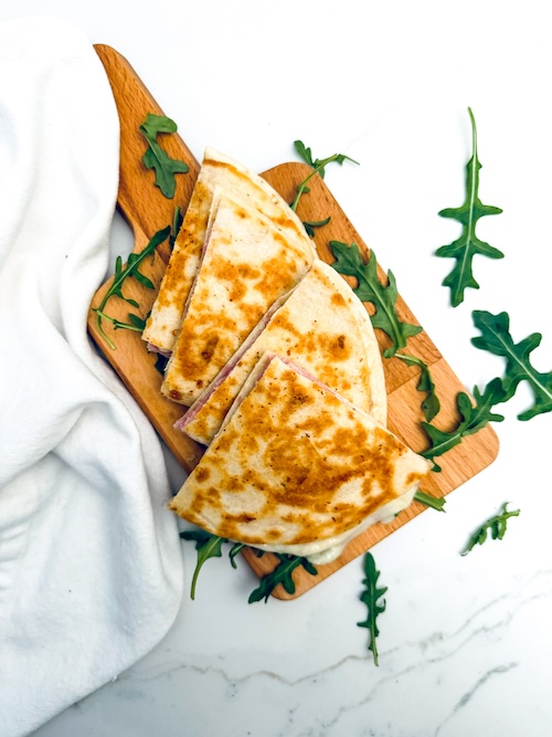 Ham and cheese quesadilla on a cutting board.