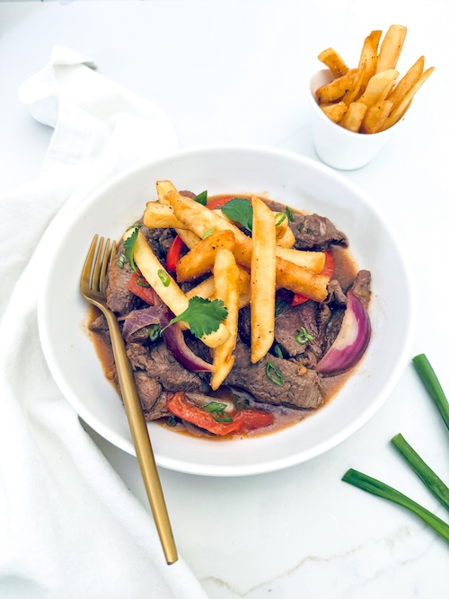 Stir fried beef and fries in a bowl.