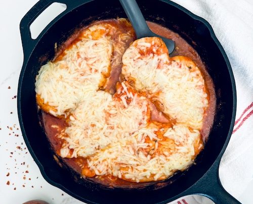 Baked chicken marinara in a cast iron skillet.