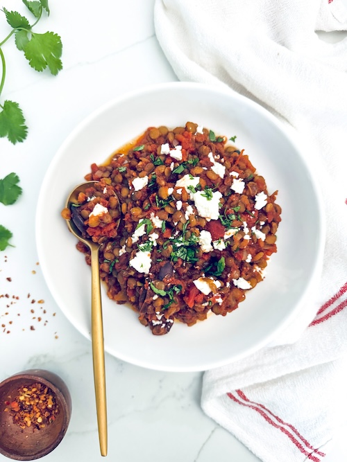 Baked lentils in a bowl topped with feta.