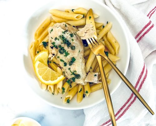 Chicken over penne in a bowl.