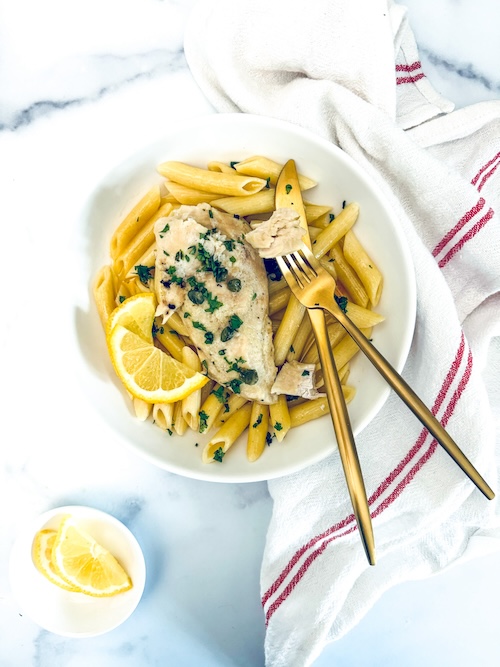 Chicken over penne in a bowl.