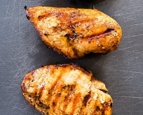 Buffalo spice marinated chicken on a cutting board.
