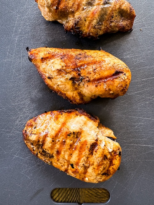 Buffalo spice marinated chicken on a cutting board.