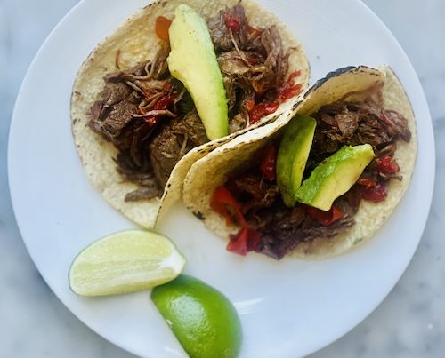 Two chipotle beef tacos on a plate.