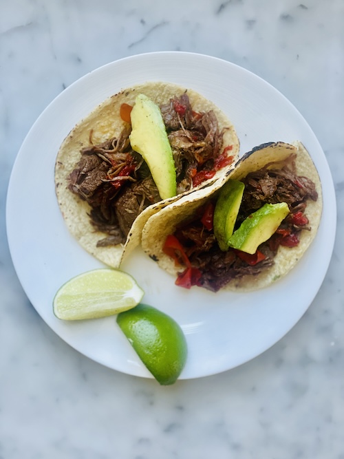 Two chipotle beef tacos on a plate.