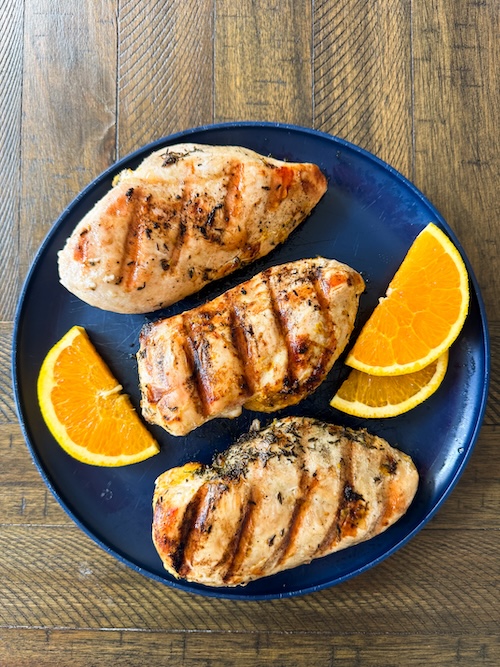 Orange marinated chicken on a plate.