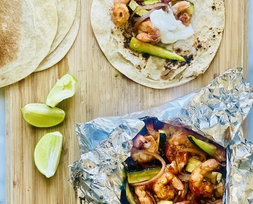 Shrimp fajitas on a wooden board.