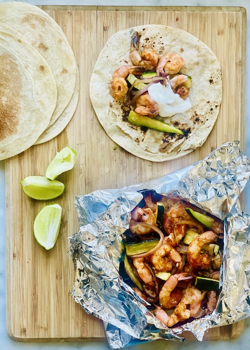 Shrimp fajitas on a wooden board.