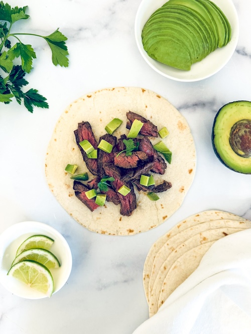 Skirt steak taco on a marble counter.