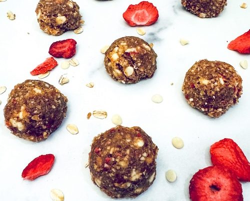 Strawberry chocolate energy bites on a marble counter.