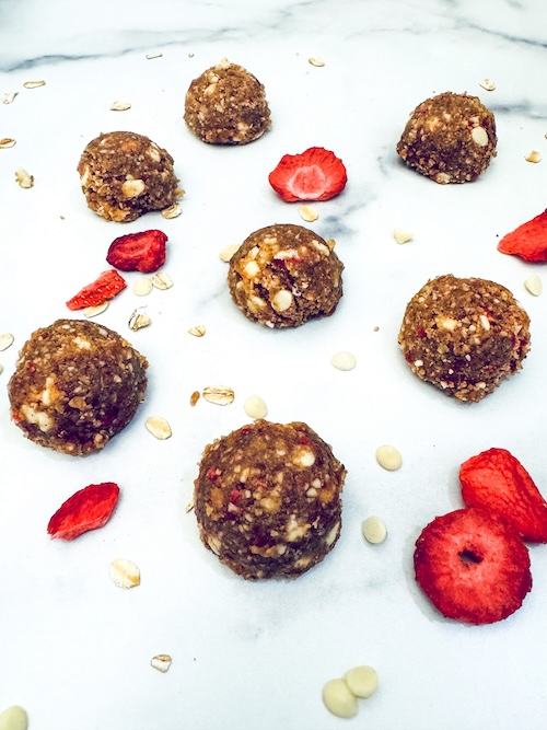 Strawberry chocolate energy bites on a marble counter.