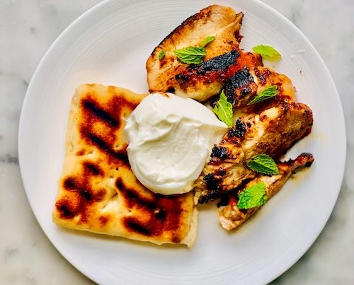 Grilled Indian-spiced chicken on a plate.