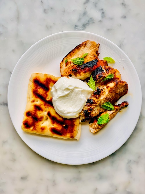 Grilled Indian-spiced chicken on a plate.