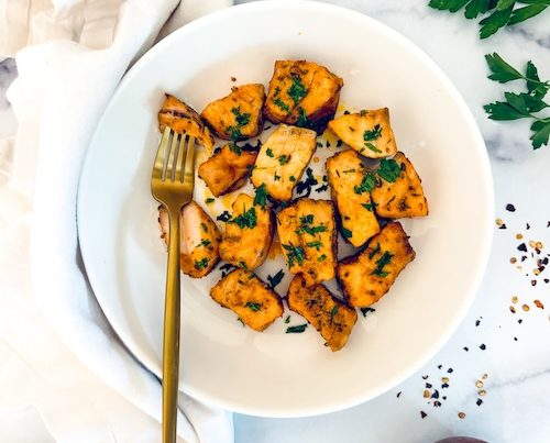 Blackened salmon bites in a white bowl.