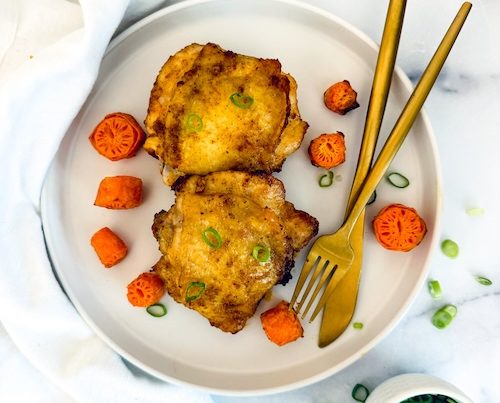 Lemon pepper chicken thighs on a plate.