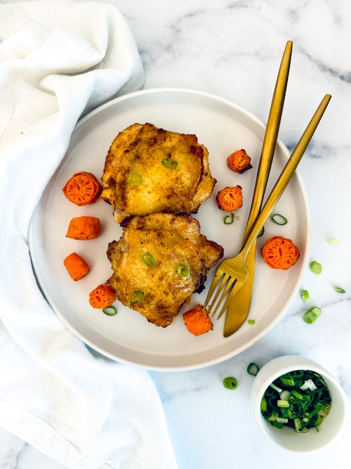 Lemon pepper chicken thighs on a plate.