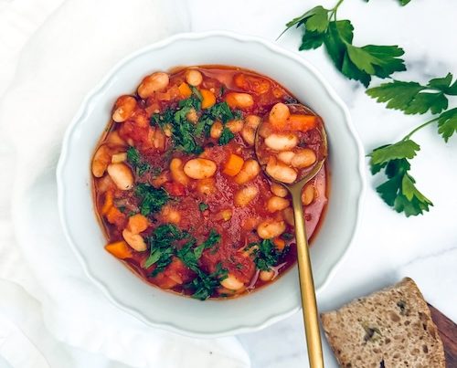A bowl of tomato and white bean stew.